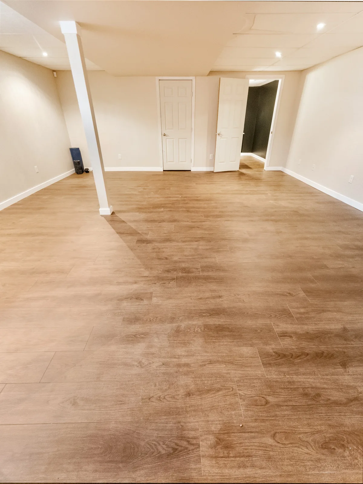 The open basement floor with its doors to the utility and spare rooms
