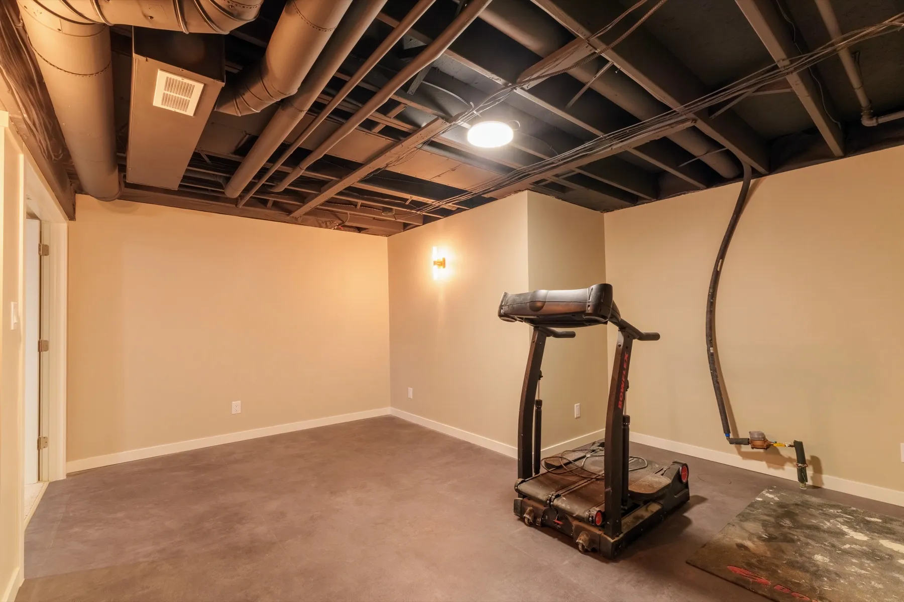 The gym area, with a hard-wearing floor and the open ceiling painted black