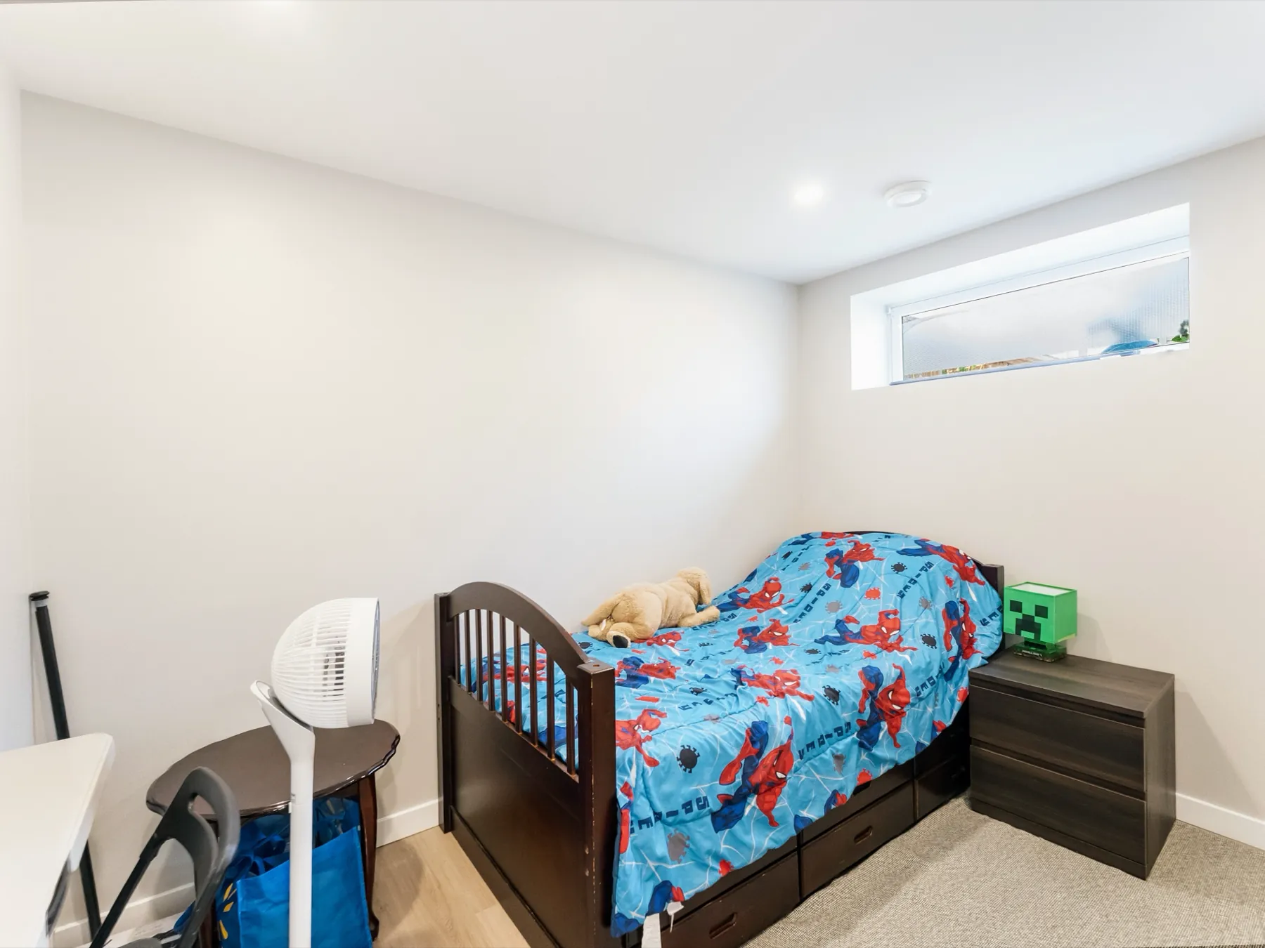 The second bedroom, carpeted and lit from an egress window