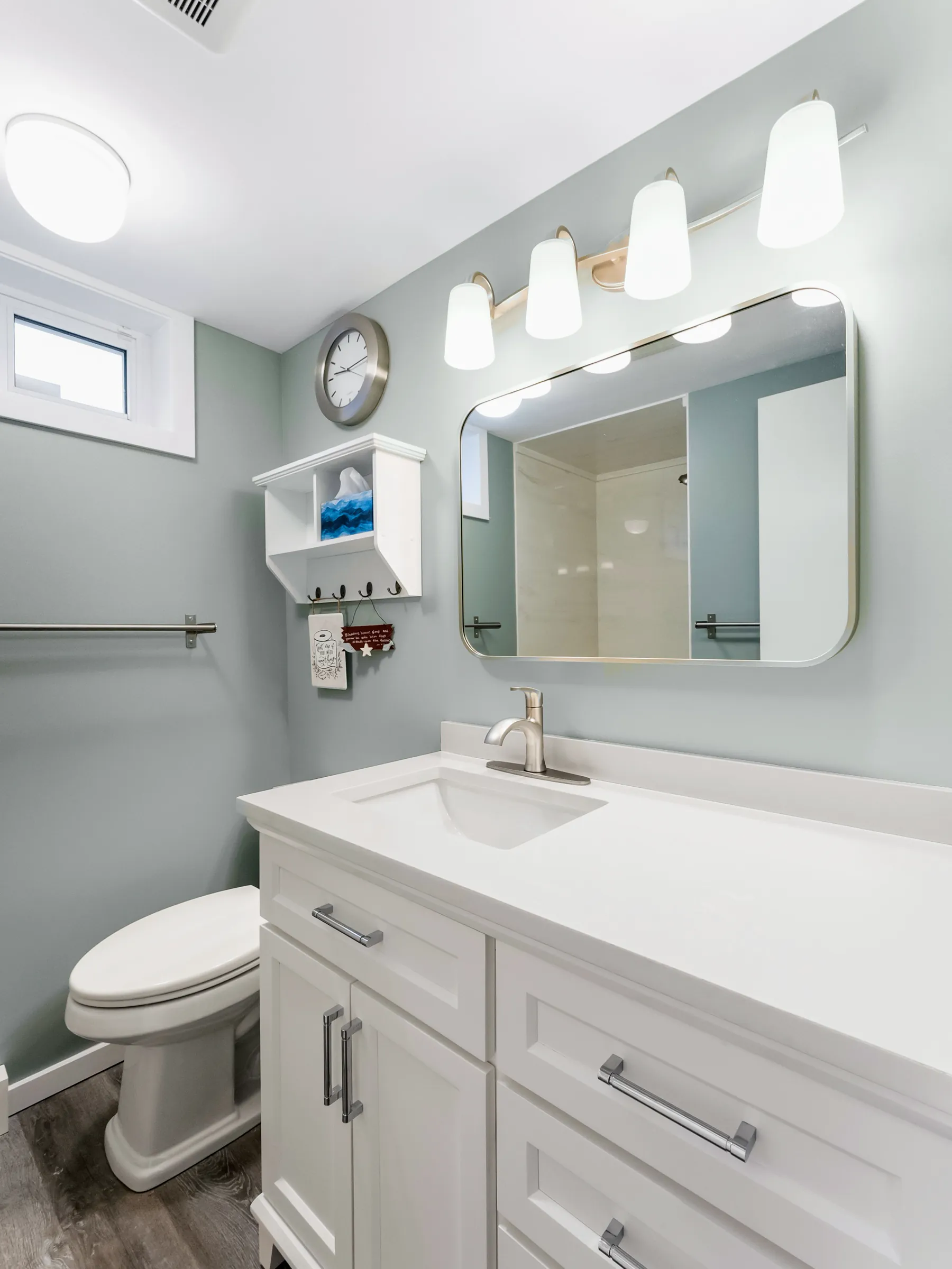 The vanity under its rounded mirror and lit sconces