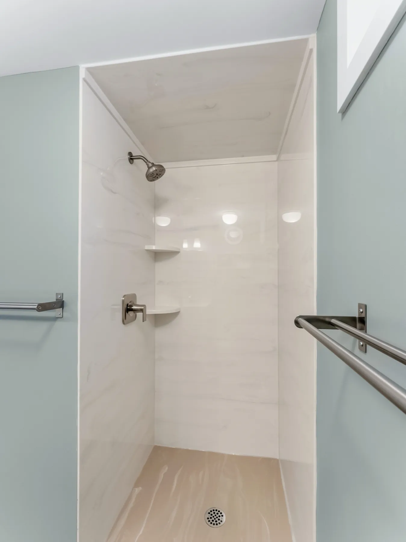 The shower entry, flush with the floor and railed on both sides