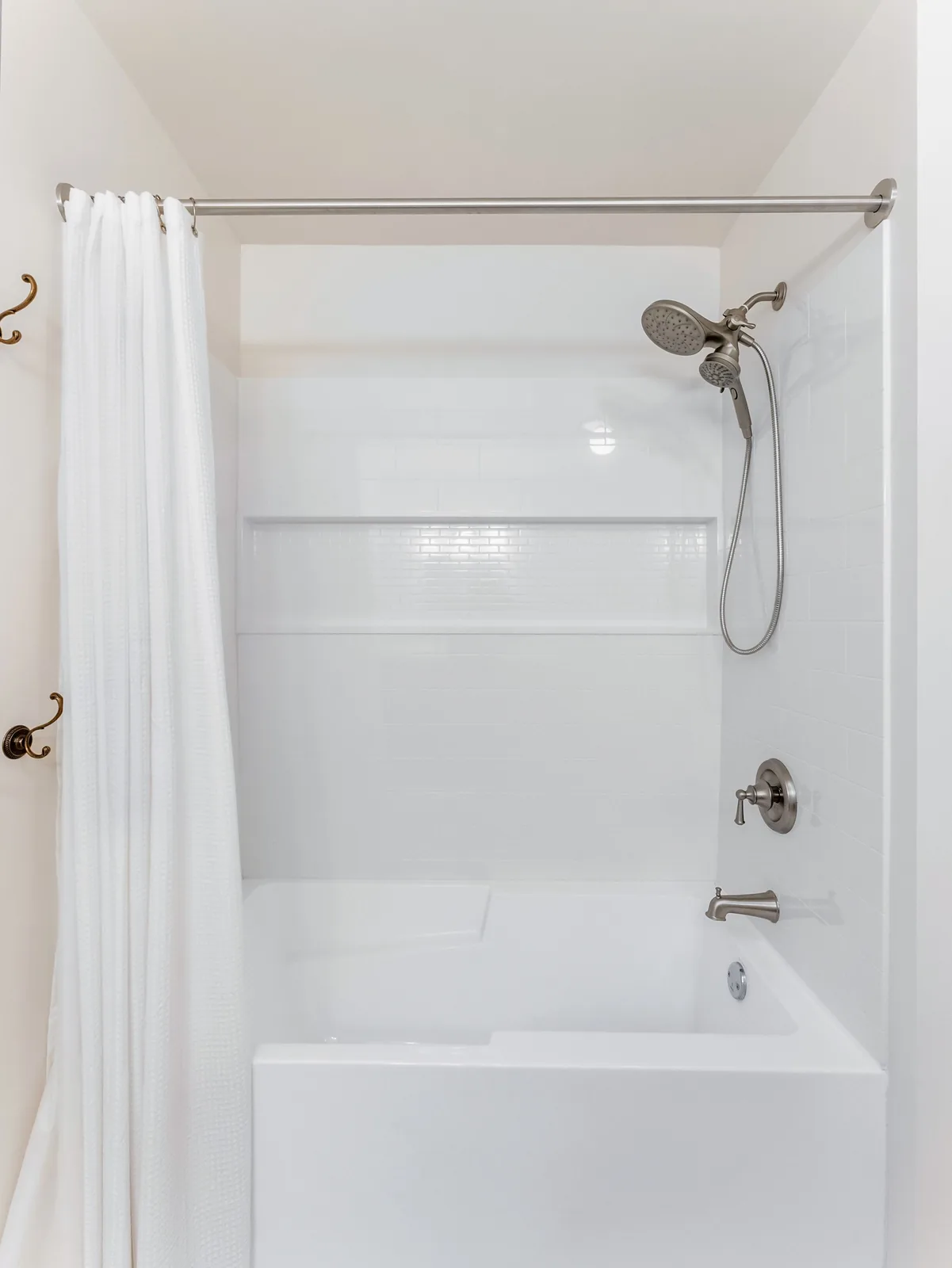 The tub and its surround from the doorway, curtain drawn back