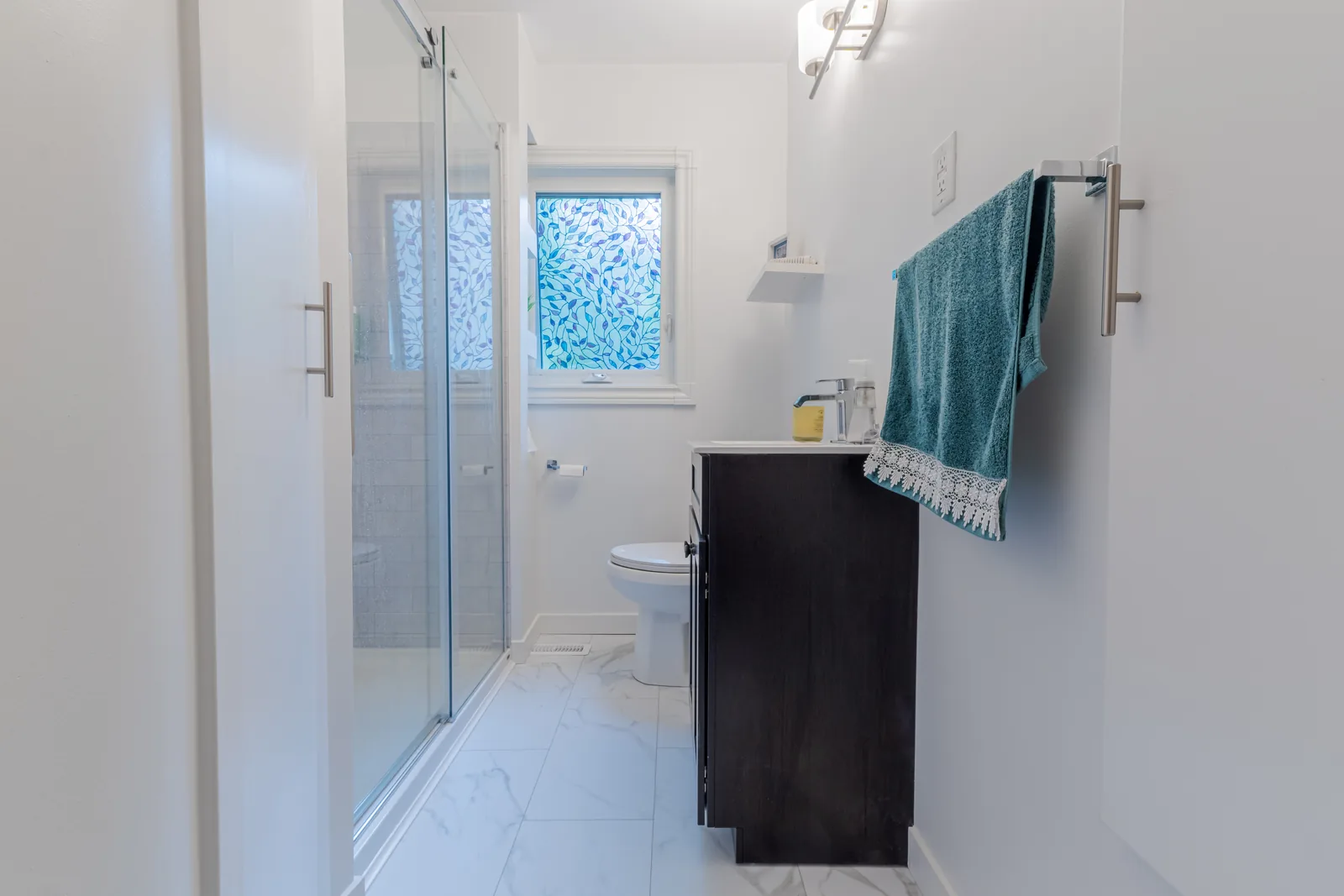 The room from the doorway, shower glass drawn across