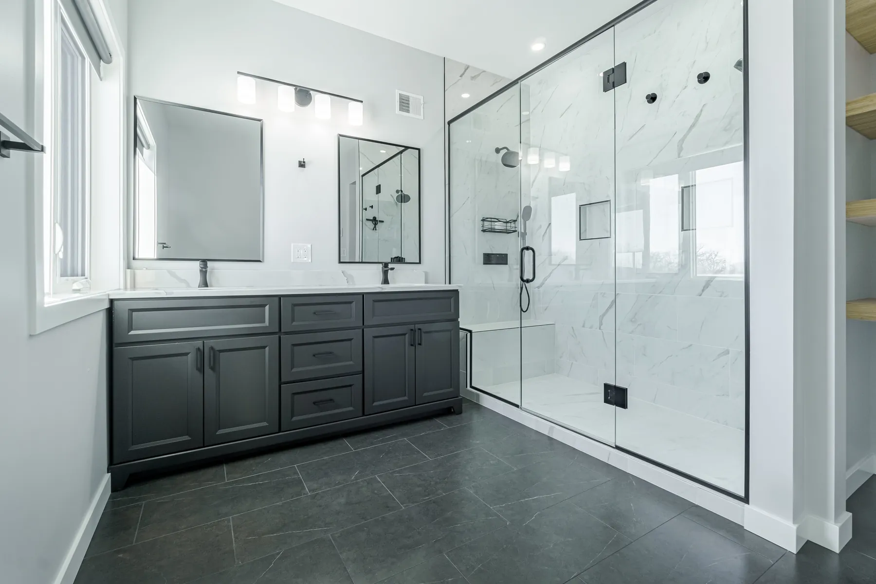 A PHS ensuite in Winnipeg — marble tile, double vanity and a glass shower