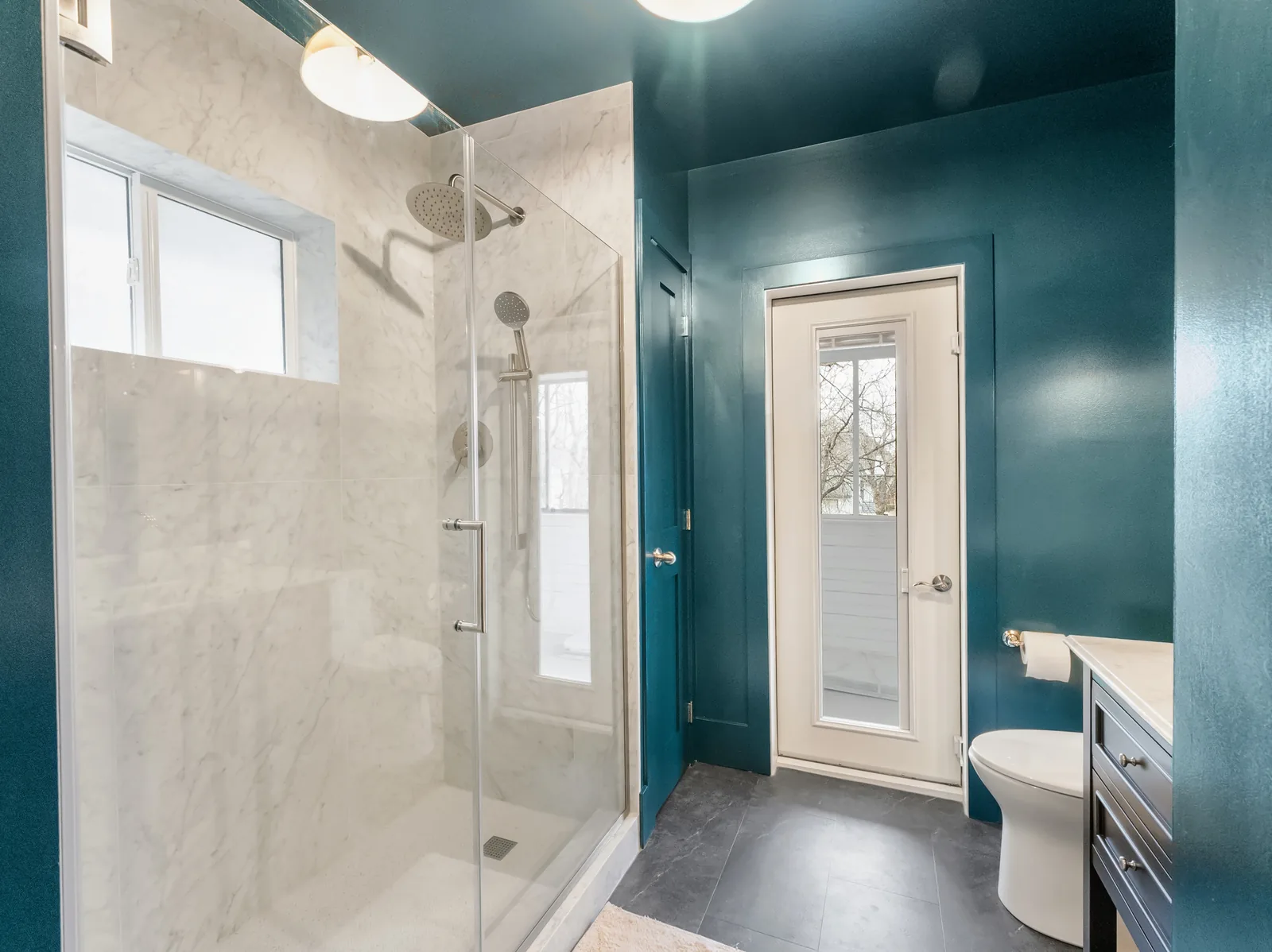 The shower from the doorway, window set into the tiled wall
