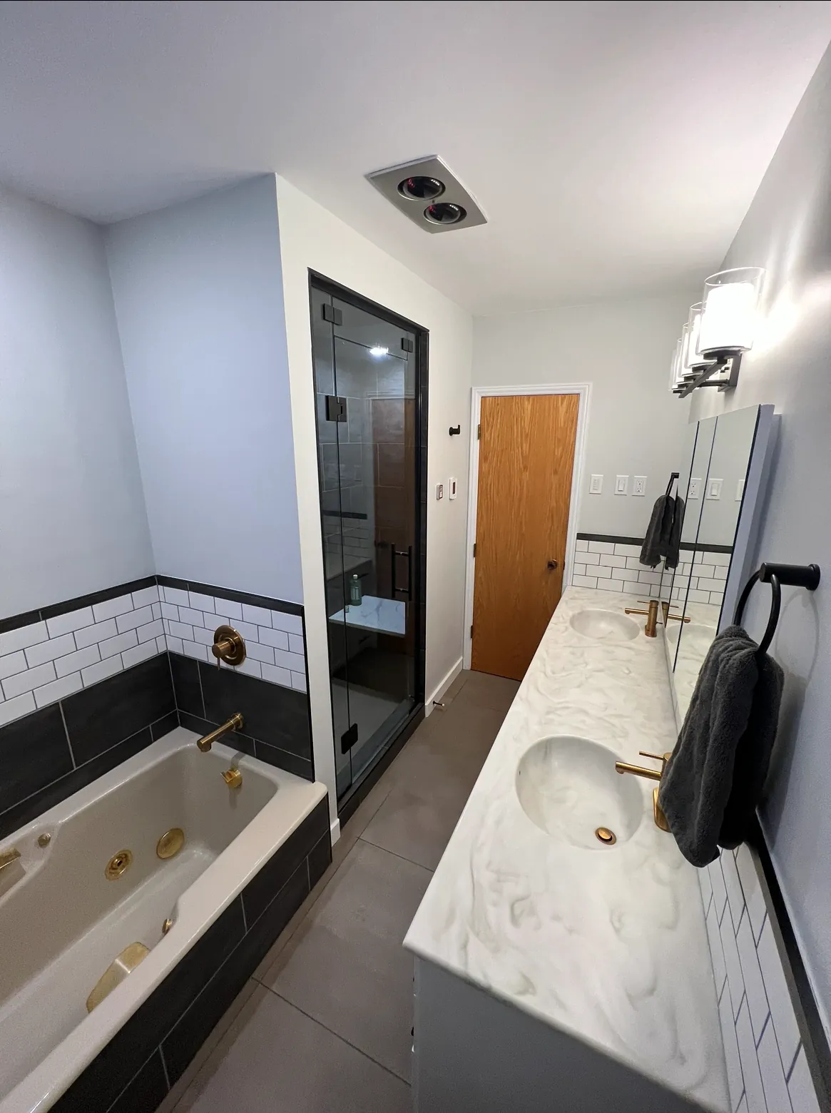 The tub and vanity run, steam shower at the far end