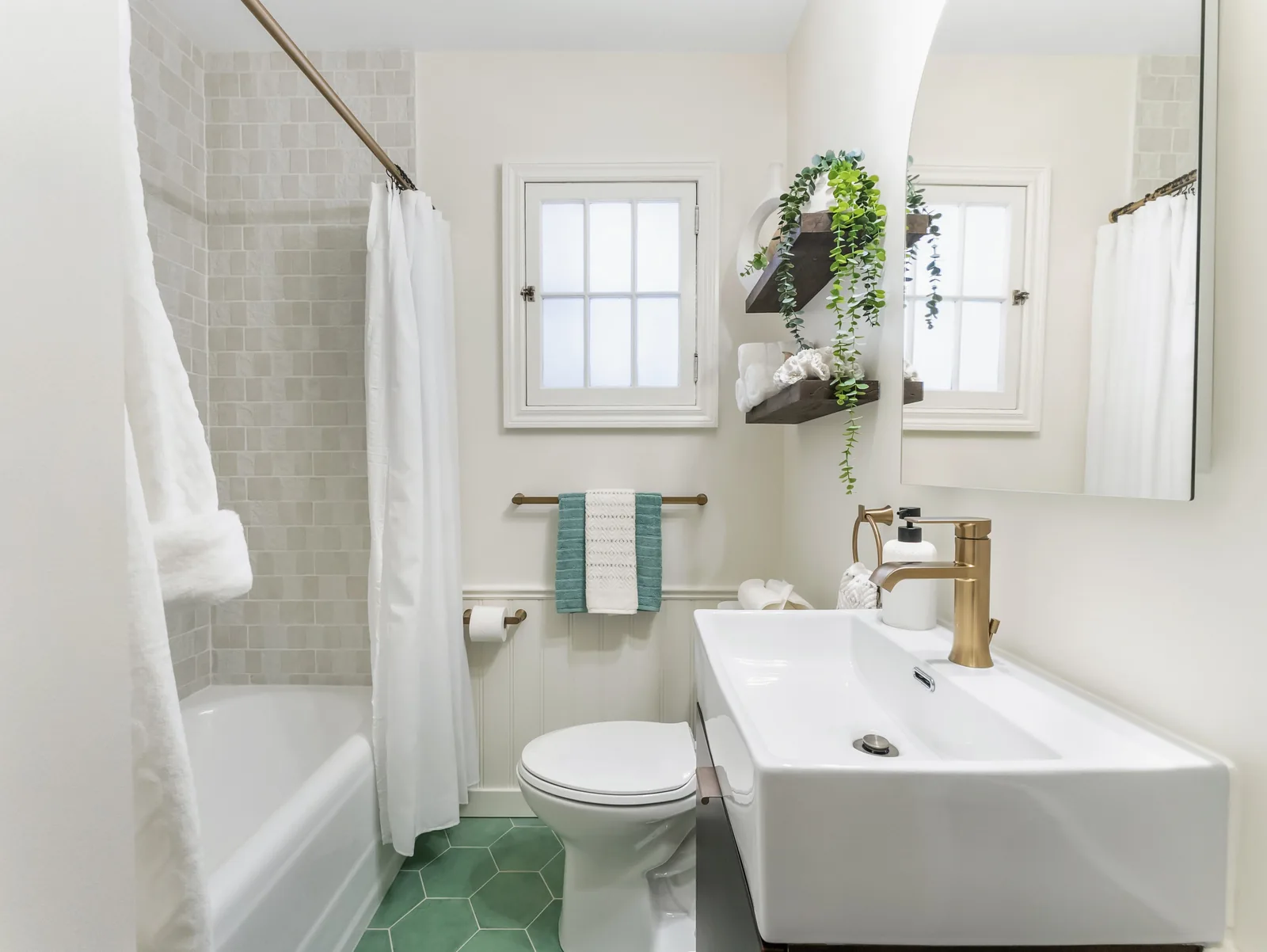 Bathroom in green hex tile and white panelling, wall-hung dark vanity beside the tub