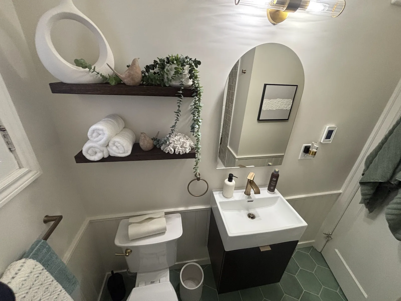 Vanity, arched mirror and shelves seen from the doorway
