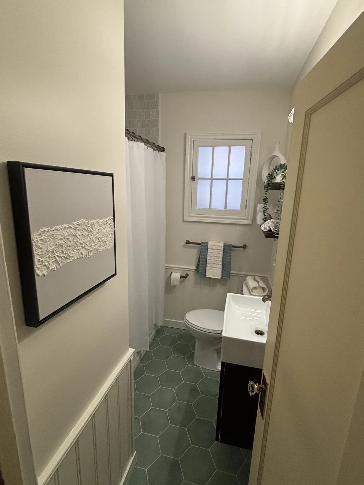 Looking down the finished room to the window, green hex tile running through