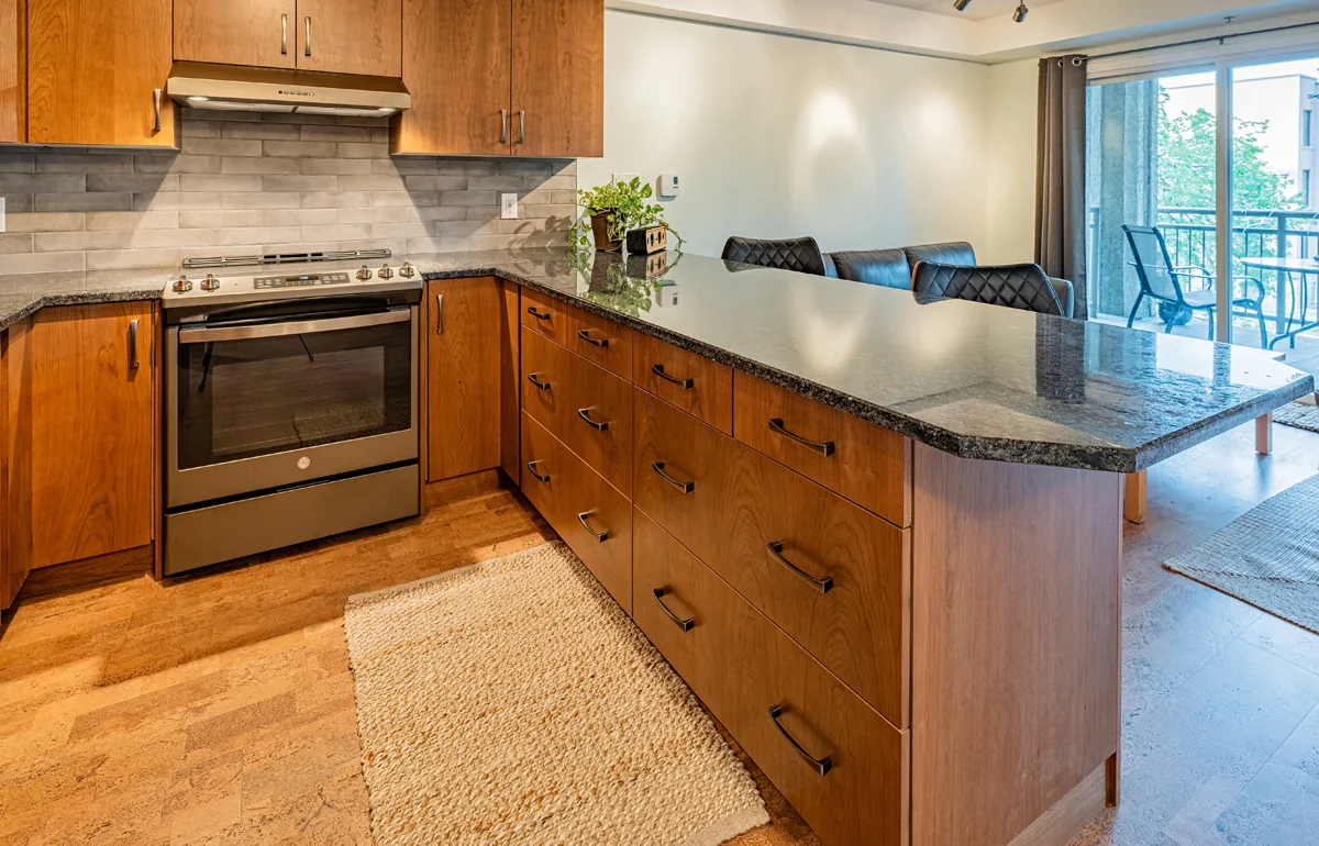 Range and counter run from the dining end, tiled backsplash behind