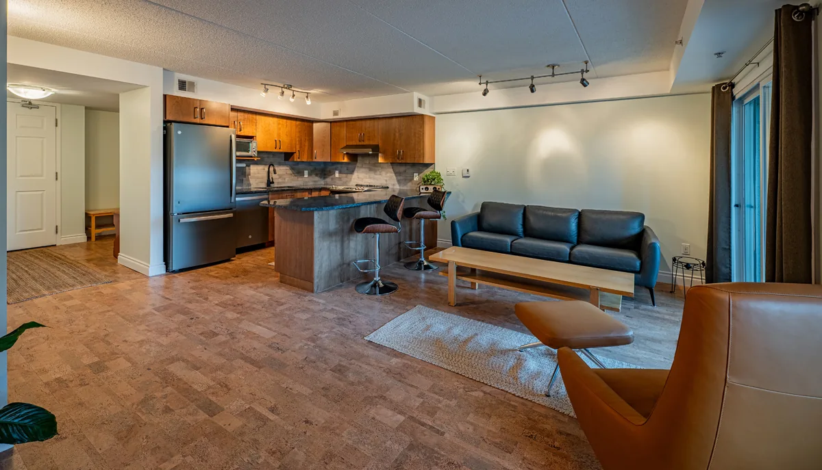Living area from the kitchen side, seating set out by the windows