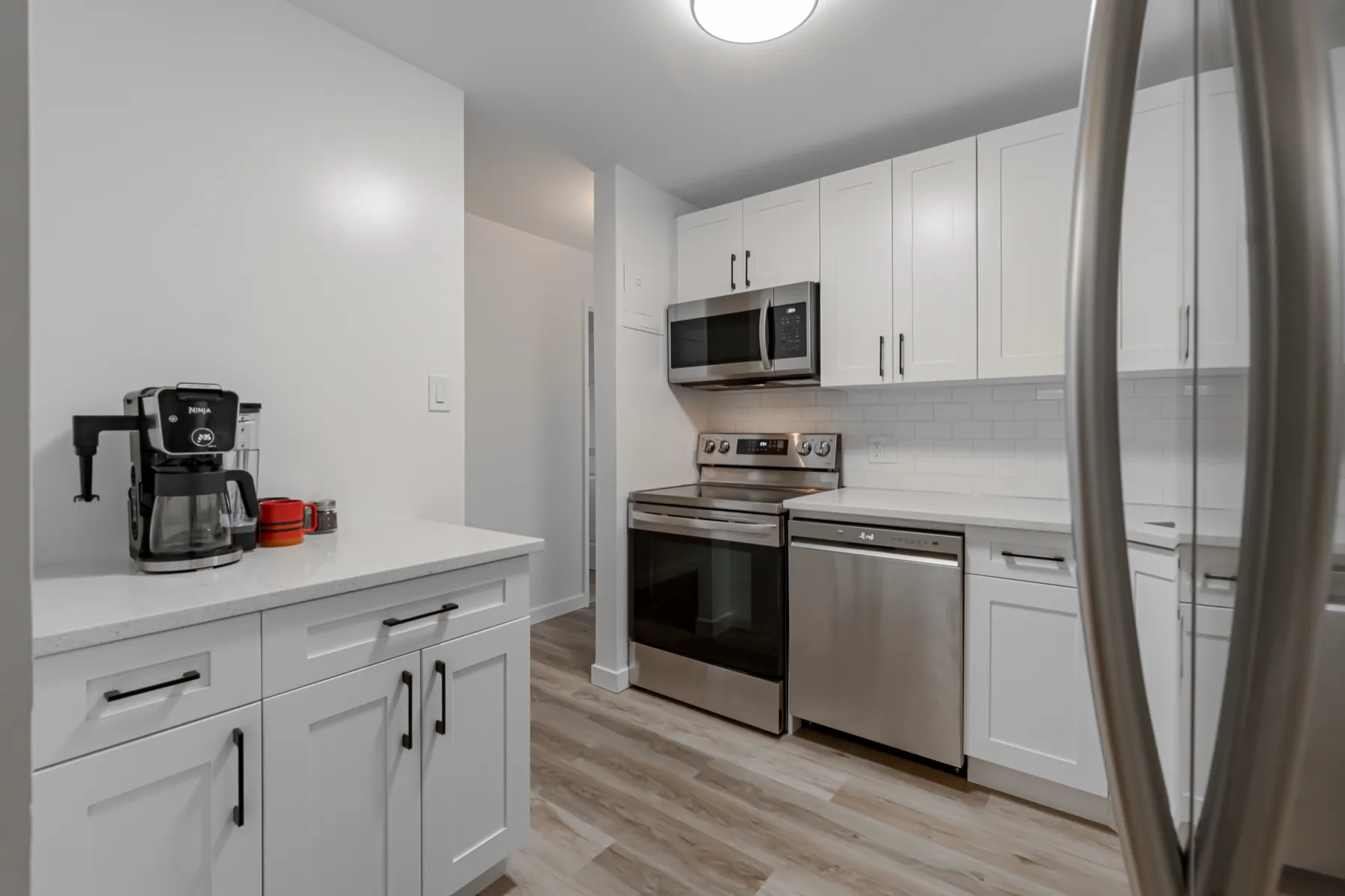 Range and dishwasher run in white shaker cabinetry