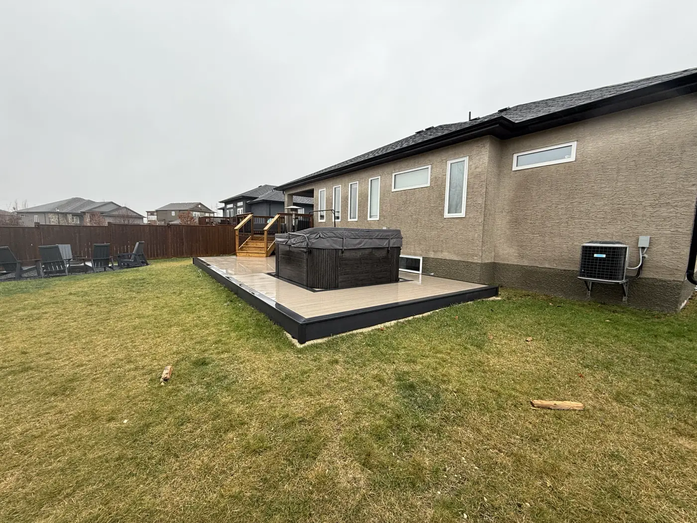 The deck along the back of the house, hot tub set into it