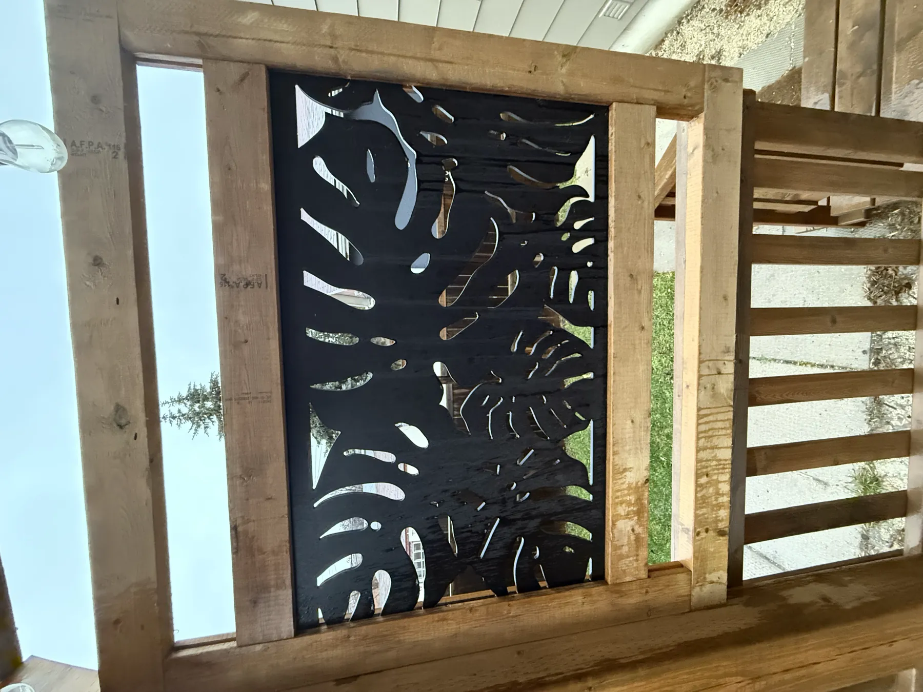 Laser-cut leaf-pattern privacy screen set into the cedar railing