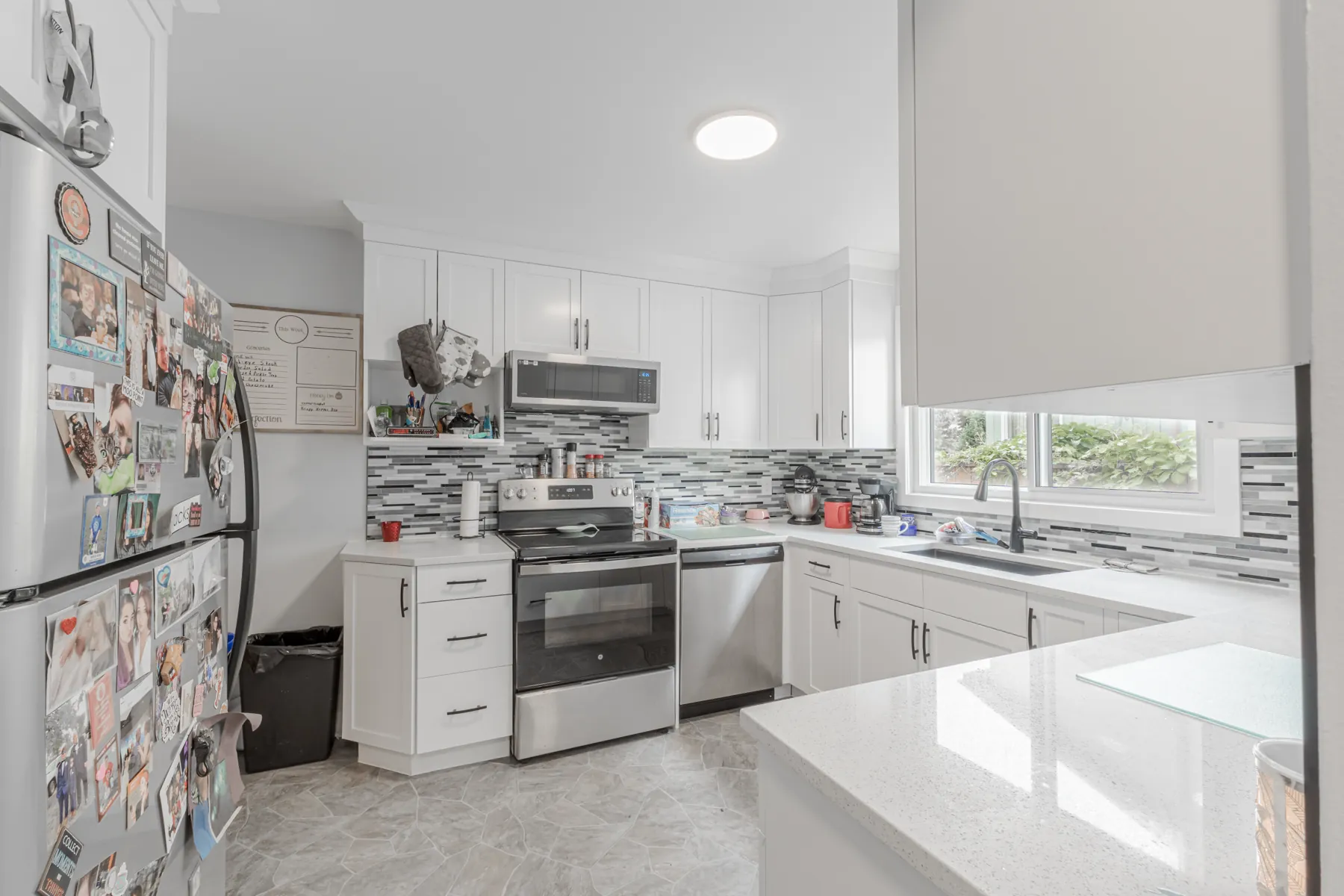 The range and fridge wall, mosaic backsplash running behind