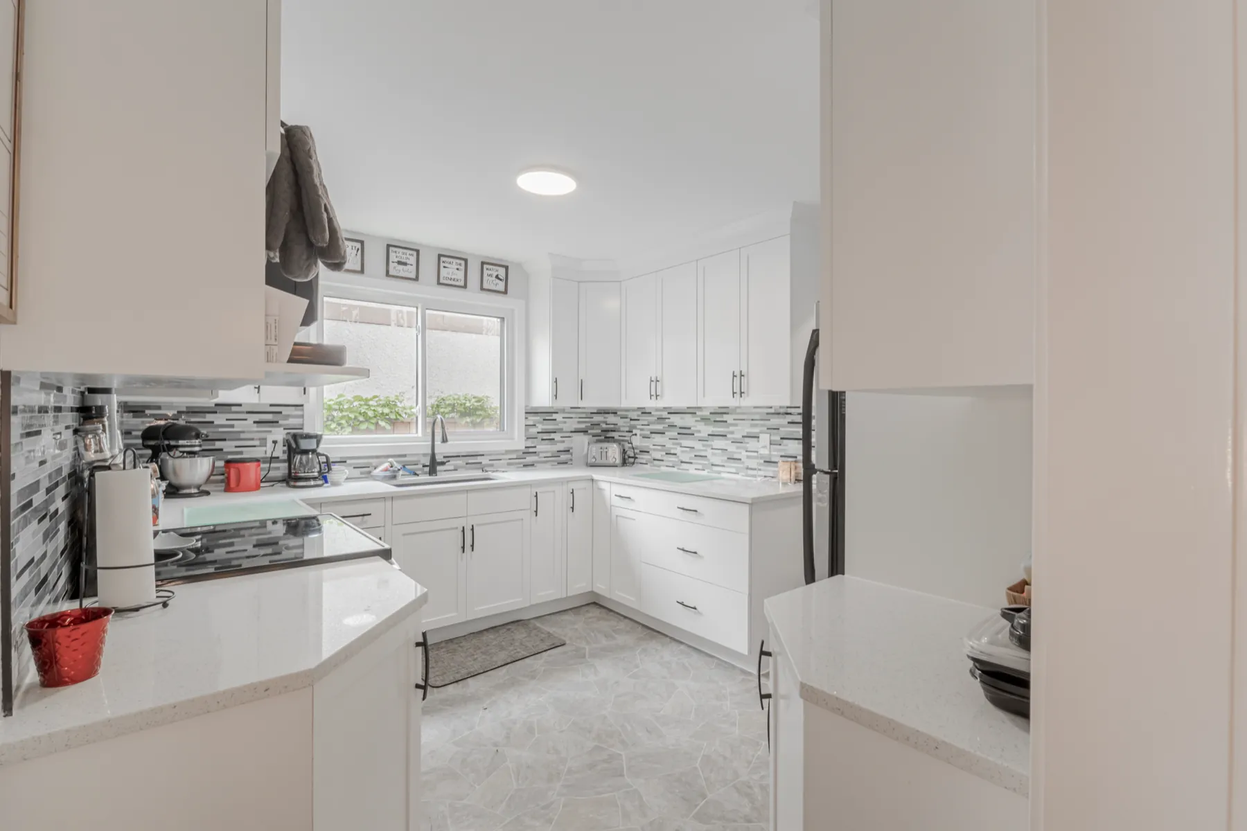 The kitchen from the dining end, mosaic backsplash under the window