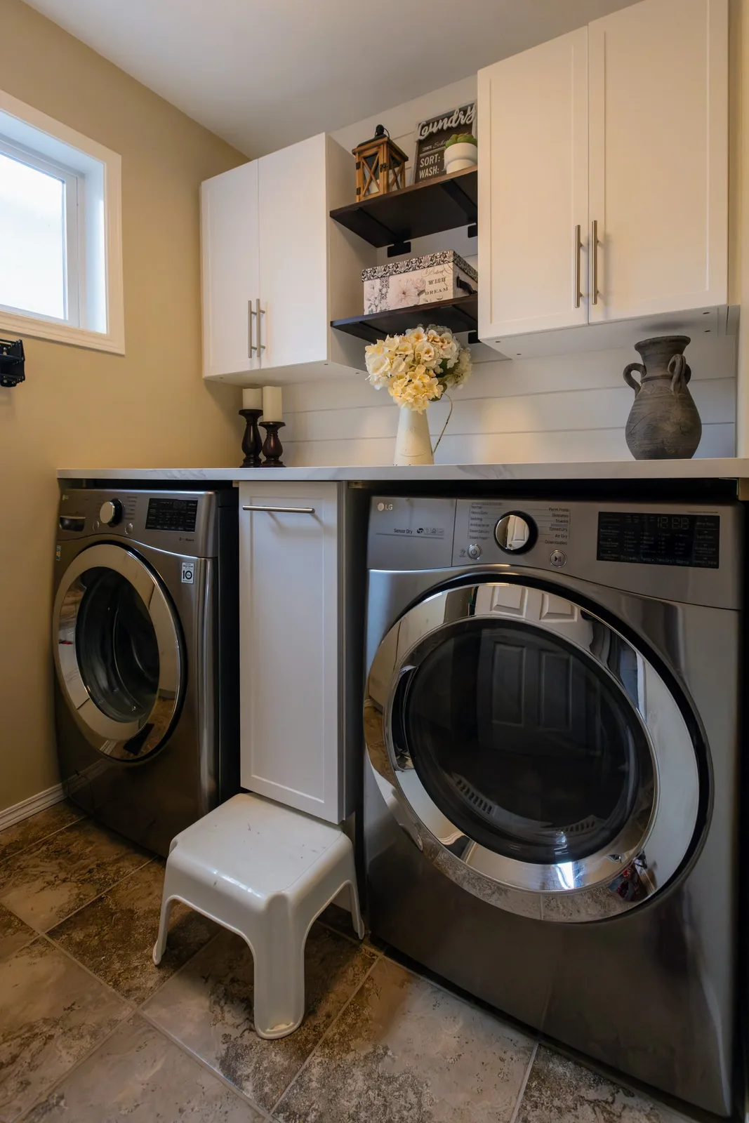 The laundry pair under their counter, cabinetry and shelves above