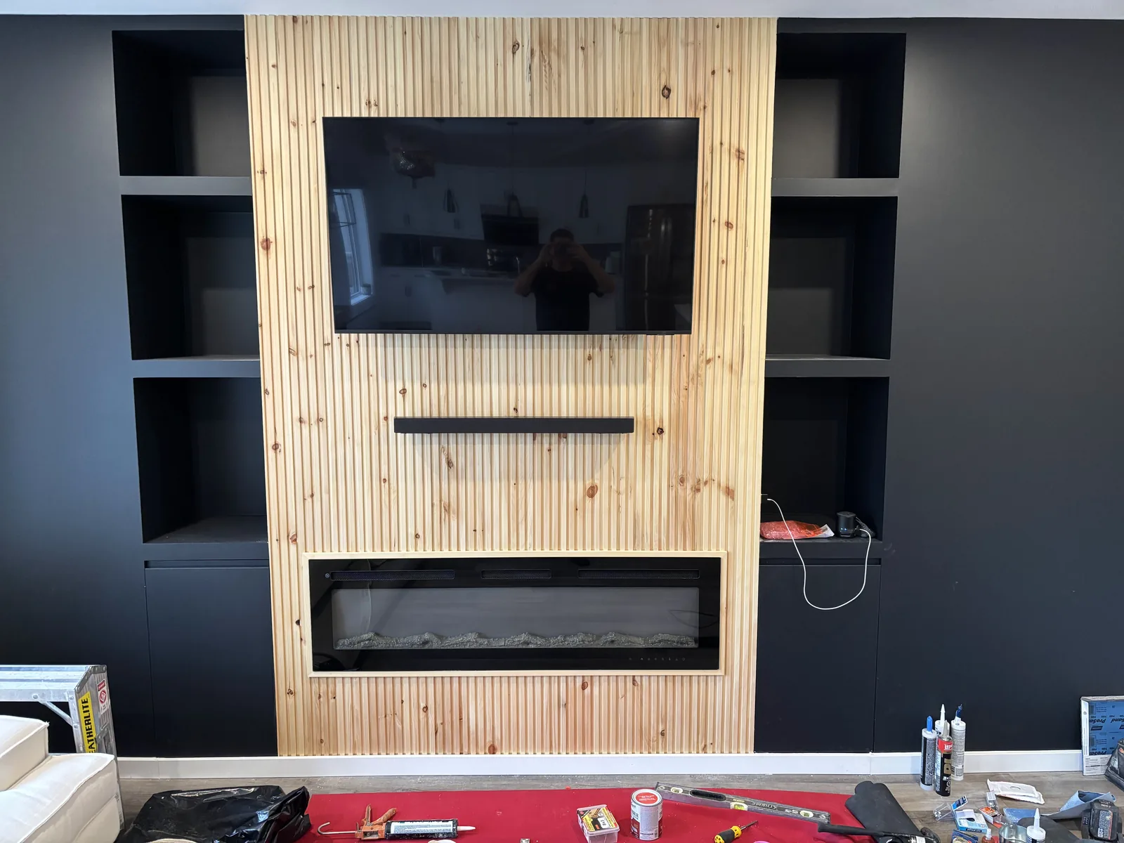 Media wall from the room, slatted timber running floor to ceiling behind the screen