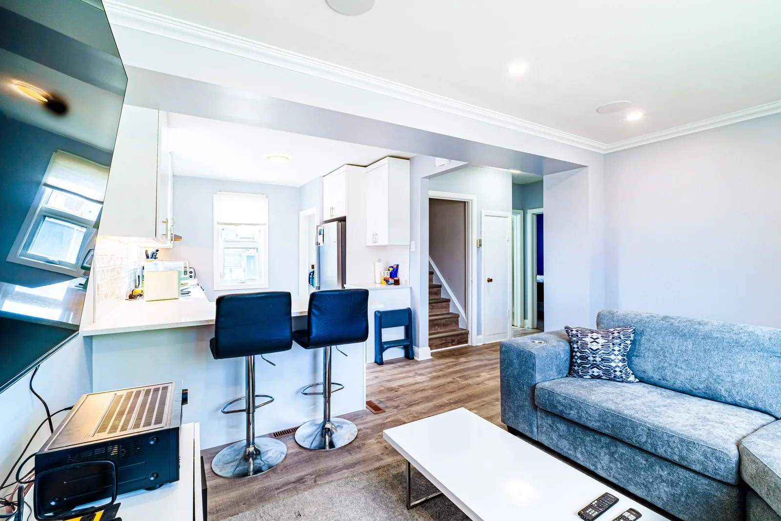 Living room seen across the island, stools pulled up to the counter