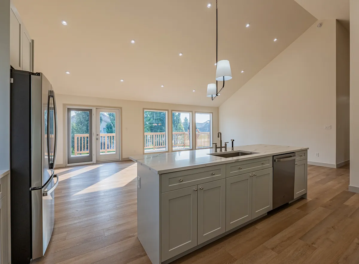 Kitchen island under the peaked ceiling, looking through to the deck doors