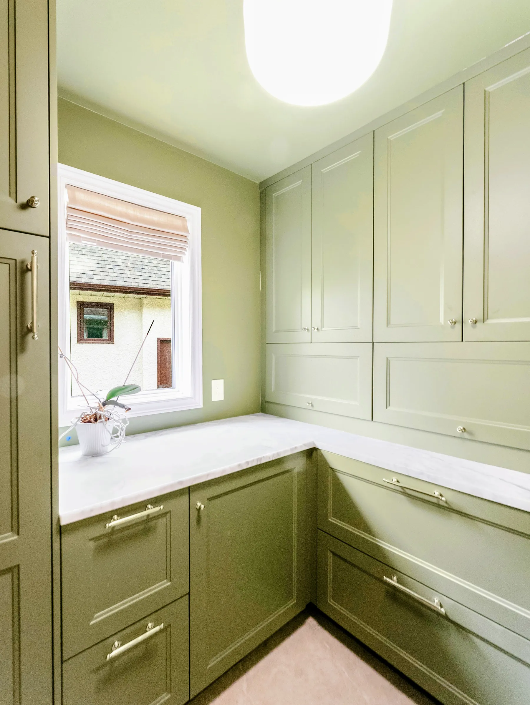 Sage-green butler's pantry with quartz counter and full-height cabinetry