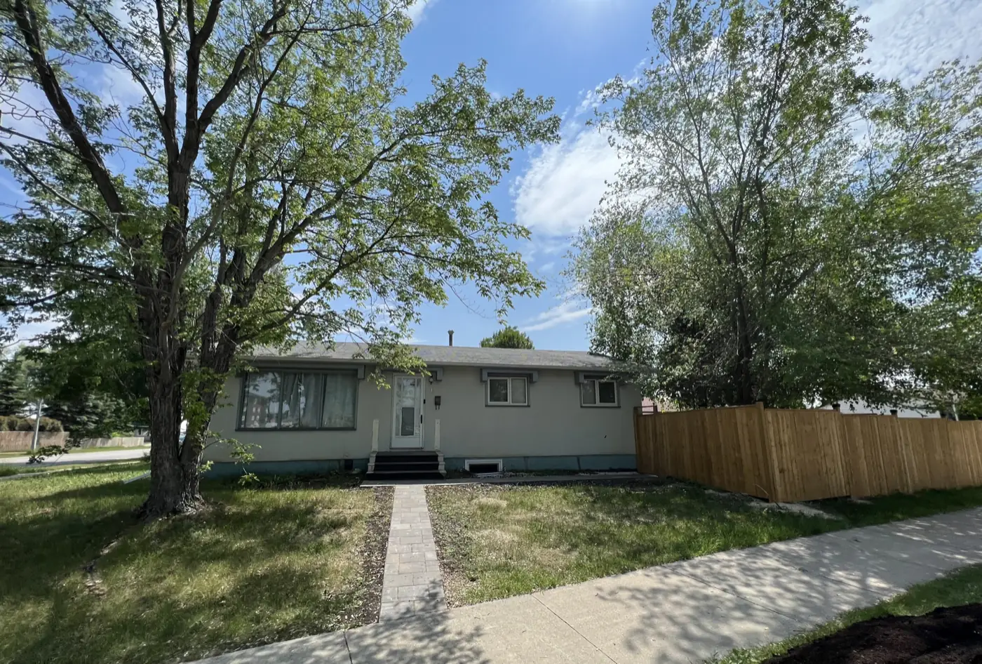 The house from the street, with its walk and fenced yard