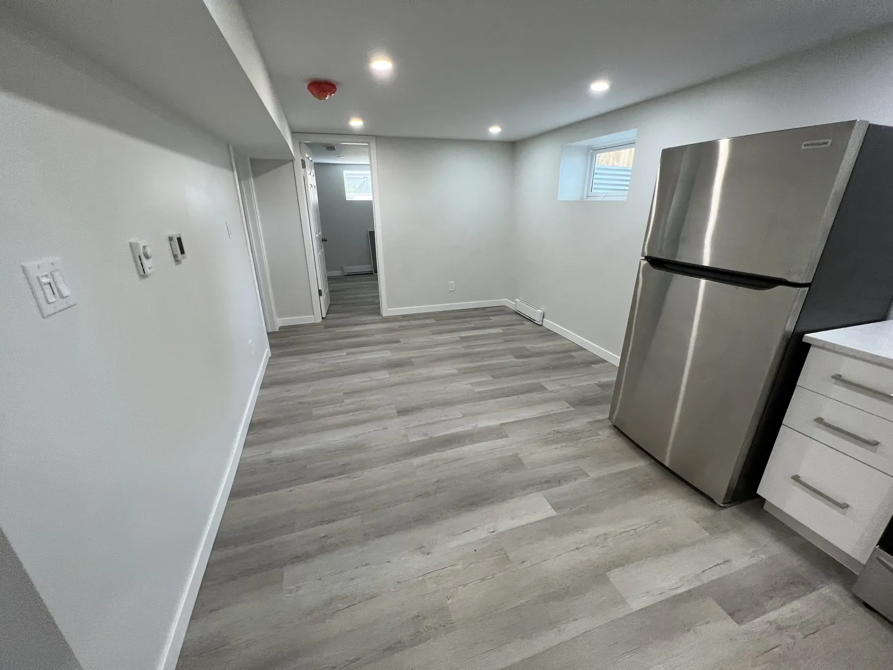 The suite's living area, its fridge and kitchen beyond