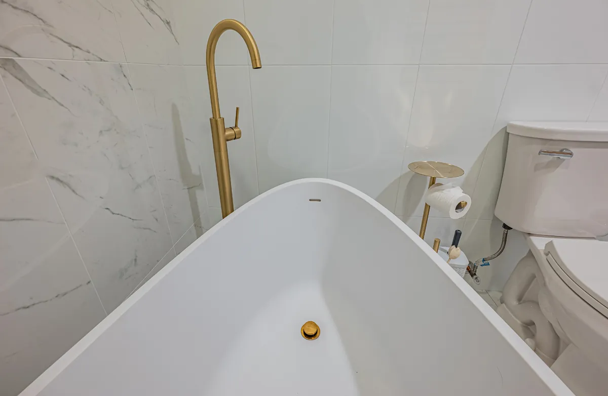 The freestanding tub with its gold floor-mounted filler