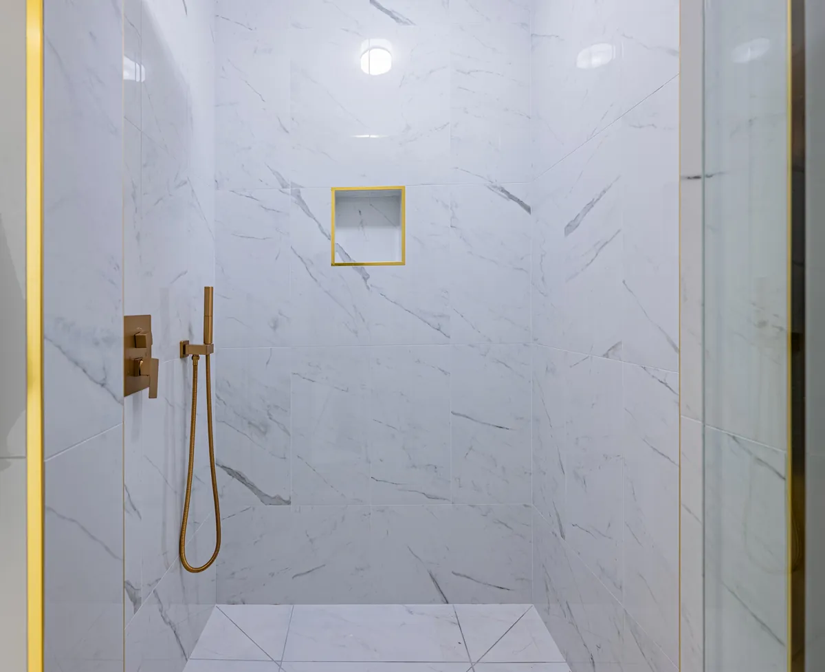Second bathroom walk-in shower, a gold-framed niche in the back wall