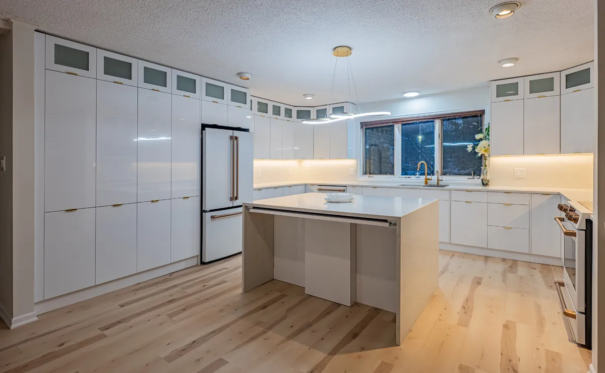 High-gloss white kitchen with a large centre island and cabinetry to the ceiling