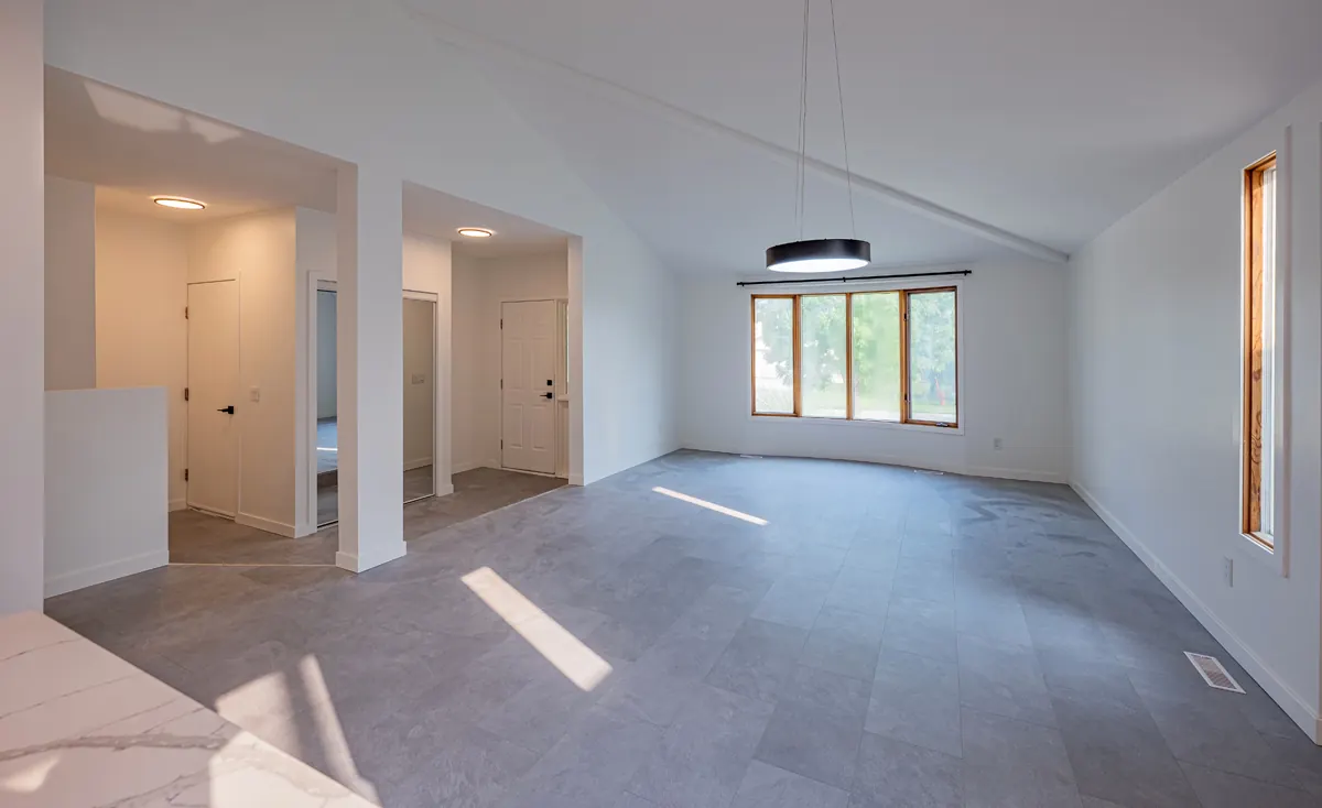The dining space beside the kitchen, a ring pendant overhead and doorways to the hall