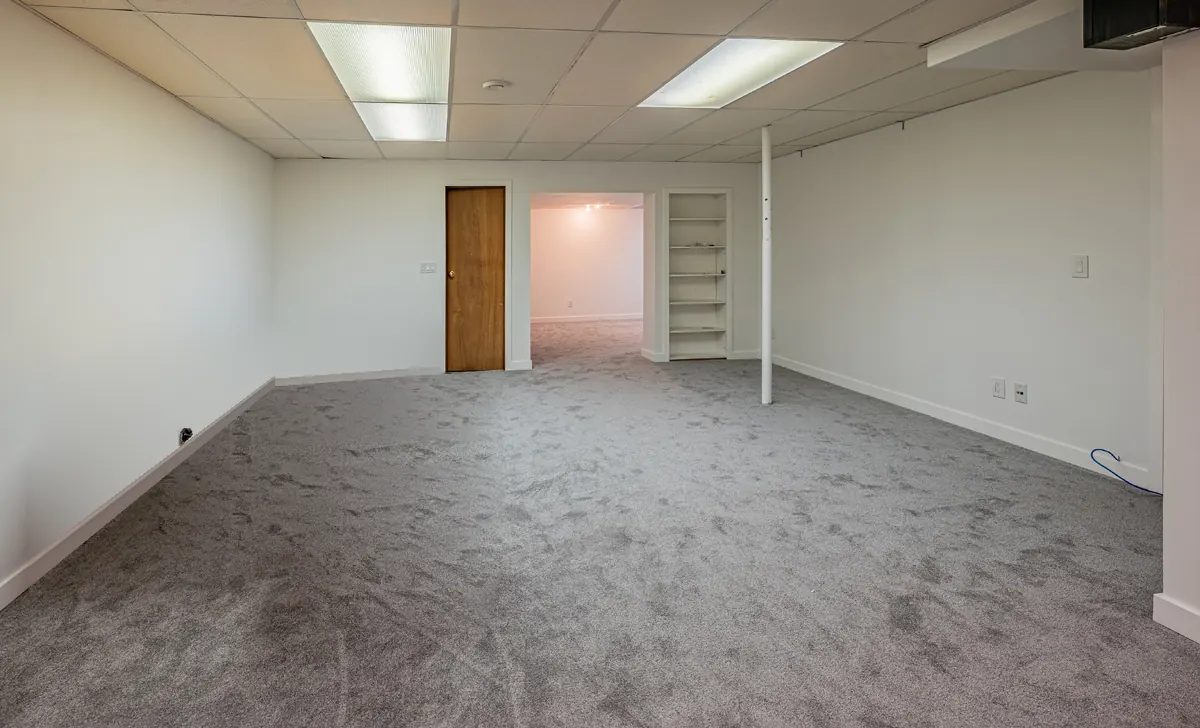 The basement's far end, built-in shelving beside the doorway