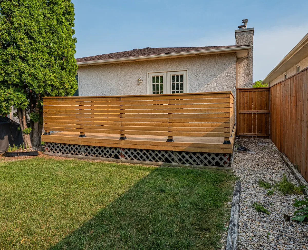 The deck's slatted screen and lattice skirting, french doors behind