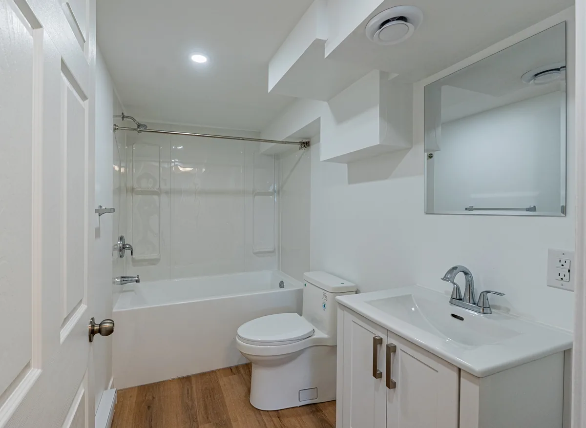 Second bathroom, vanity and tub-shower under a sloped ceiling
