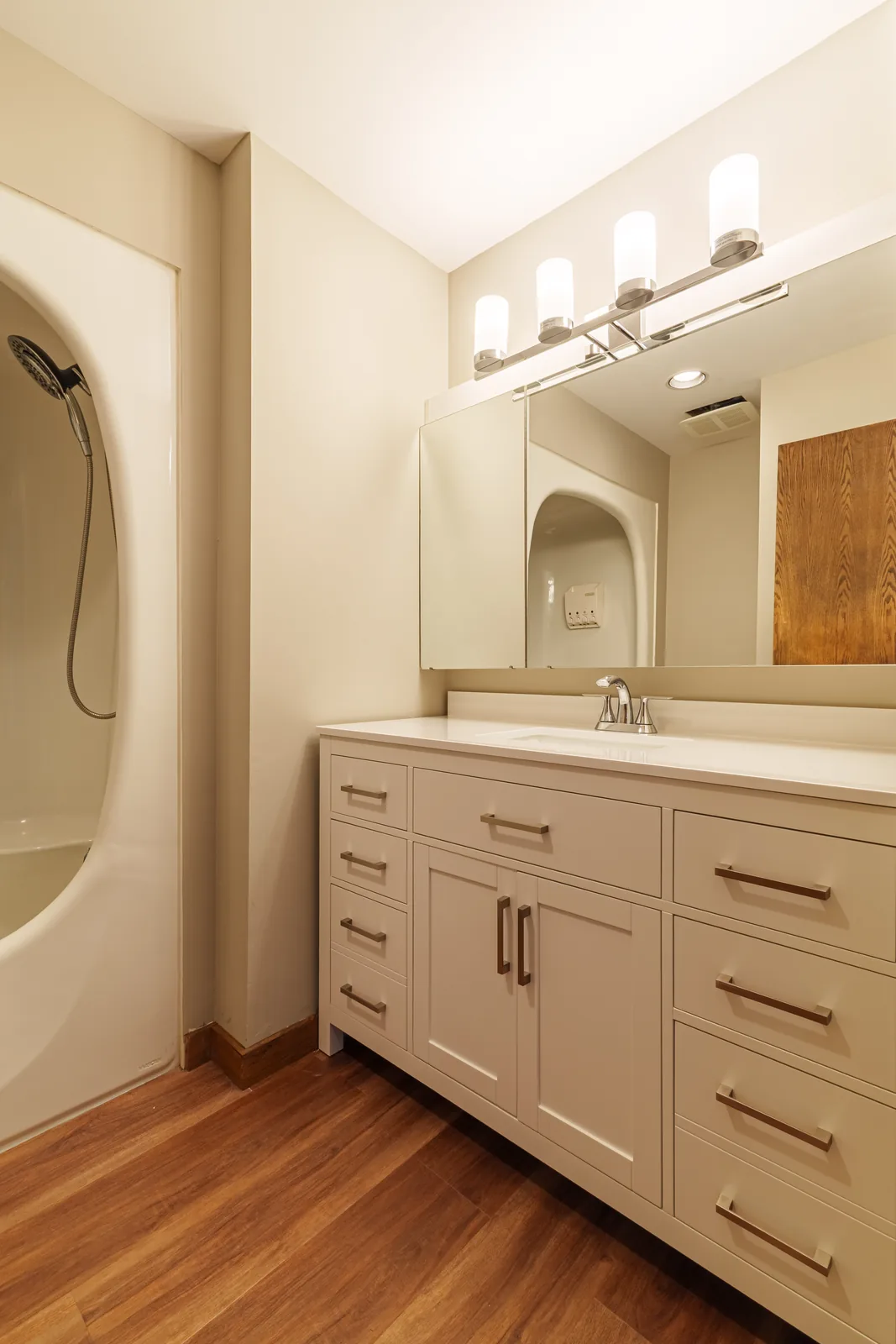 New vanity and mirror in the bathroom, arched shower niche alongside